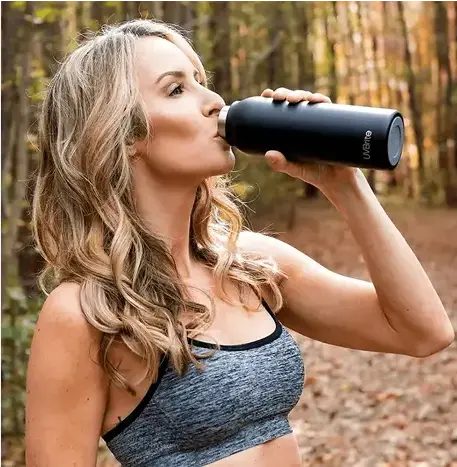 Woman drinking clean water at gym